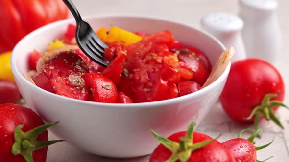 Summer tomatoes and onion salad in a white bowl