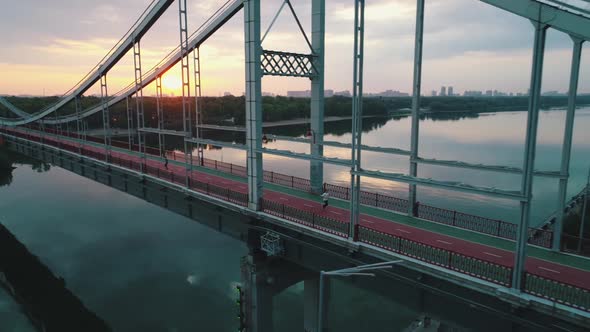 Guy Runs on a Bridge in the City Aerial View