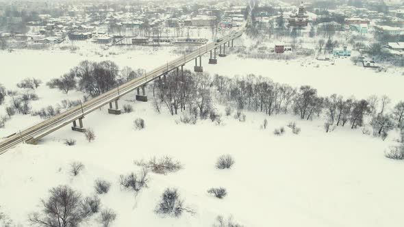 Fabulous Winter Landscape with a Frozen River and a Road Bridge Aerial View