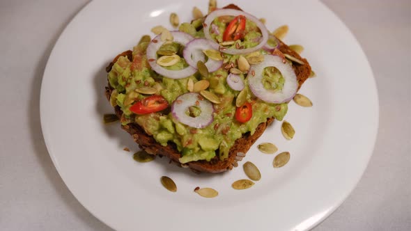 Uhd 11 Z 3Avocado sandwiches,with peanuts and pumpkin seeds, onion rings, red pepper on a white back
