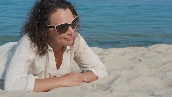 Happy woman is lying on the sea background.