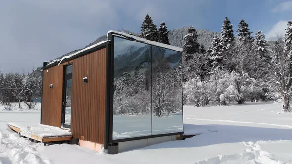 Aerial View of an Innovative High-tech House with Mirrored Walls Amid a Winter Forest in the