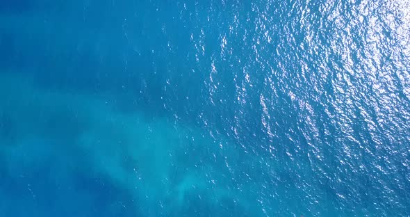 Wide aerial tourism shot of a sunshine white sandy paradise beach and aqua turquoise water backgroun