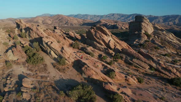 Desert landscape - Aerial footage of mountains and dry land with blue cloudy sky in the background.