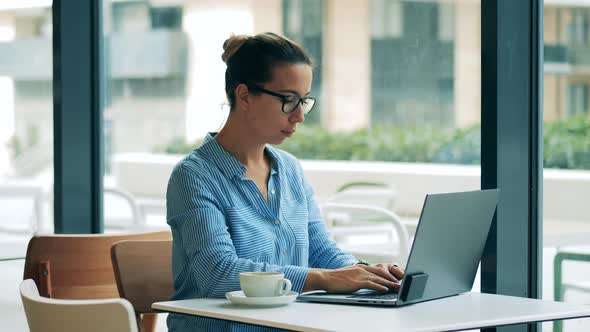 Female Freelancer Is Working with a Computer in a Cafe