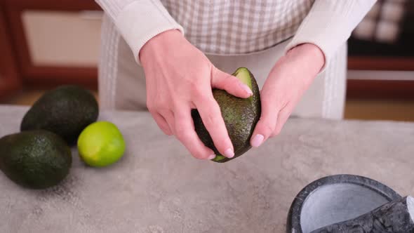 Close Up of Woman Hands Halving Avocado at the Domestic Kitchen