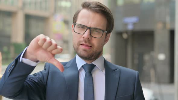 Portrait of Middle Aged Businessman showing Thumbs Down Gesture, Outdoor