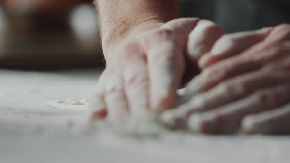 Hands of Male Chef Piling Flour on Table