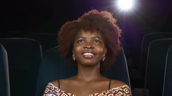 Portrait of Smiling African American Watching Movie in Theater. Close Up