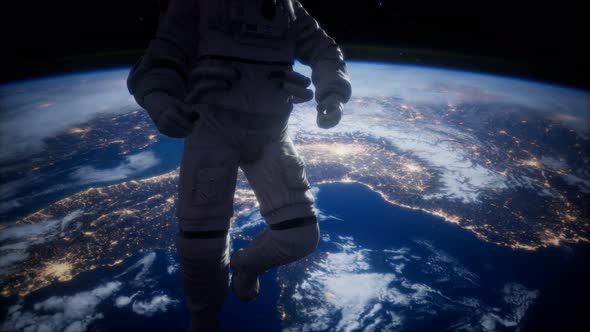 Astronaut in Outer Space Against the Backdrop of the Planet Earth