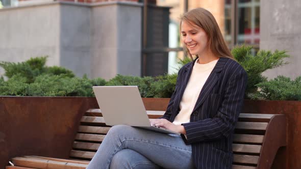 Web Video Chat on Laptop While Sitting on Bench Outside Office