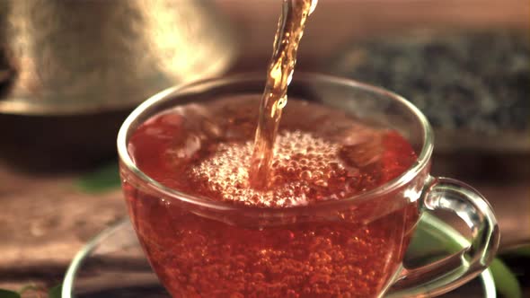 A Super Slow Motion Jet of Tea Pours Into a Cup of Air Bubbles