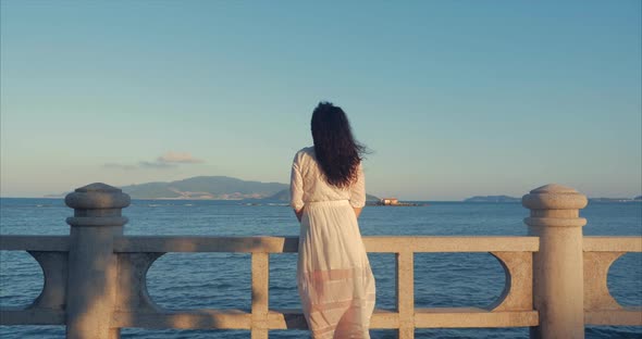 Wonderful Caucasian Woman Looking at Ocean View at Sunset. Young Beautiful Girl Enjoying Nature