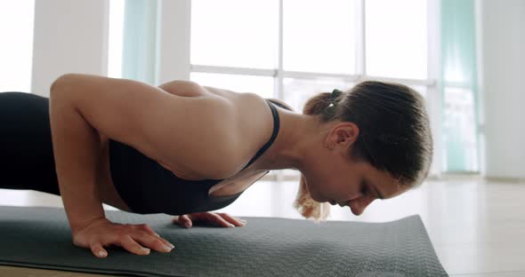 Athletic Beautiful Woman Does Pushups As Part of Cross Fitness Gym Training