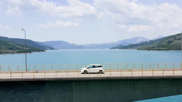 Car Passing Bridge Over Lake