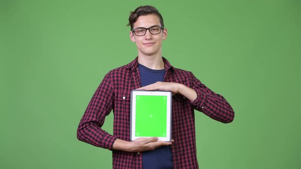Young Handsome Teenage Nerd Boy Showing Digital Tablet