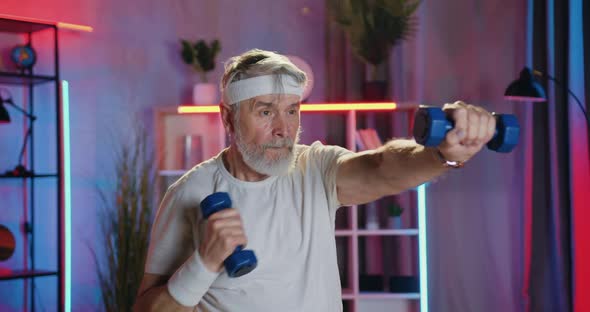 Senior Man in Sportswear Doing Boxing Exercises with Dumbbells