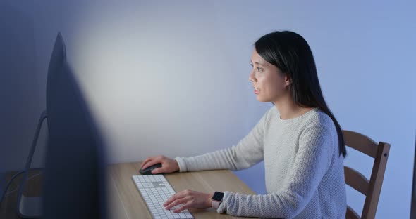 Woman work on computer at home in the evening