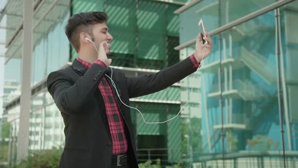 Static Side View of Positive Indian Young Man Having Video Chat