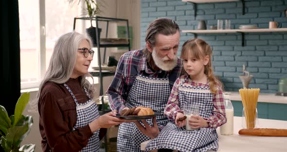 Senior Grandparents Couple with Dgranddaughter Cooking in Kitchen