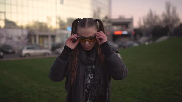 Cocky Young Woman Walks Along the Street in the Evening and Calls for Herself