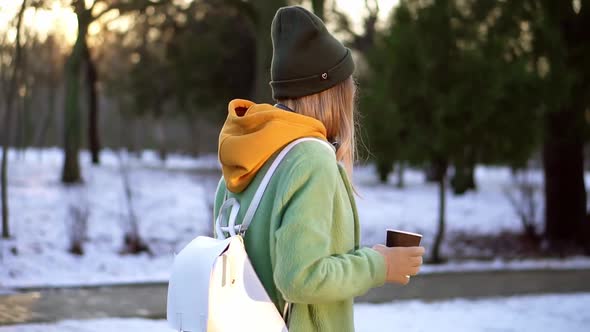 Woman Walking with Hot Drink By Winter City Park Enjoy Weather Side View