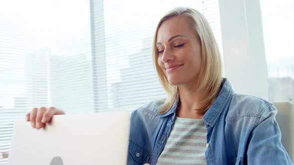 Businesswoman closing laptop at her desk