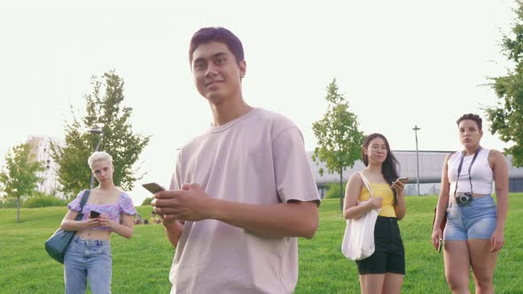 Slow motion young happy asiatic man outdoor using smartphone