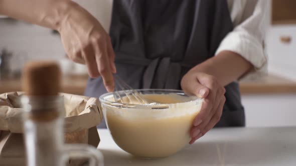 Process Of Making Dough, Woman's Hand Beats Eggs, Flour In Bowl Next To Paper Bag For Dough