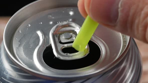 plastic straw held in metal pull tab of soda can