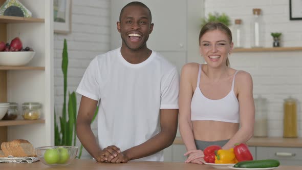 Sporty Woman and African Man Talking on Video Call in Kitchen