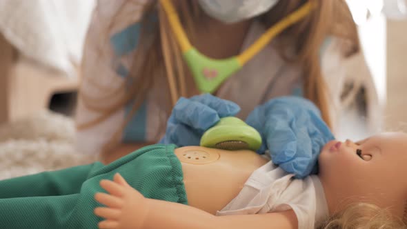 Beautiful Little Girl Playing Doctors with Doll at Home