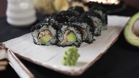 The camera circles around the sushi set on a white clay plate