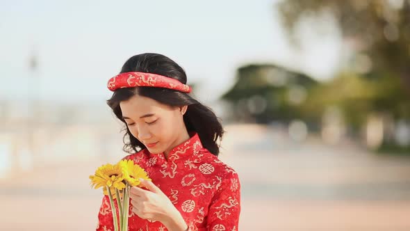 Beautiful Vietnamese Girl in Red Traditional Dress Ao Dai with Yellow Flowers