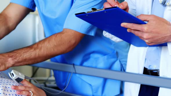 Doctor consulting pregnant woman in ward