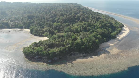 Aerial: flying over Ai island coral reef sand beach Banda Islands Indonesia