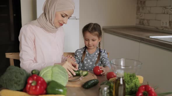 Pretty Muslim Mother and Daughter Preparing Tasty Food at Kitchen