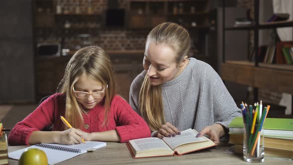 Mother Helping Her Daughter with Homework at Home