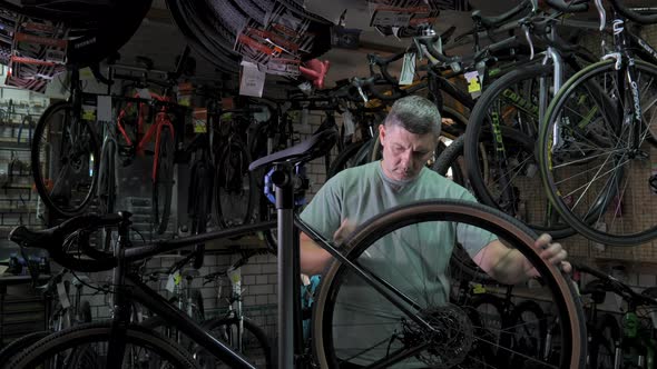Service Engineer Performs Diagnostics and Repairs of Bicycle in Professional Workshop