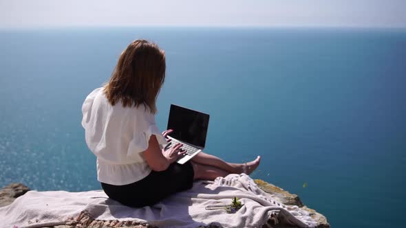 Successful Business Woman Working on Laptop By the Sea