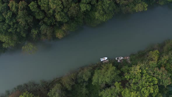 A drone flight over a thick green forest and a river running through it