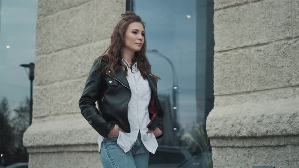 Portrait of a Young Woman in a Leather Jacket on the Street. Hipster Girl Walking in the City