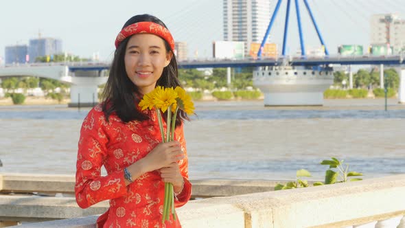 Beautiful Vietnamese Girl in Red Traditional Dress Ao Dai with Yellow Flowers