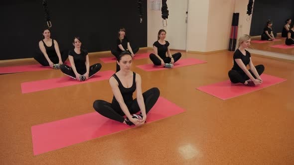 Young Girls Play Sports in the Gym on Mats, They Do Stretching Exercises.