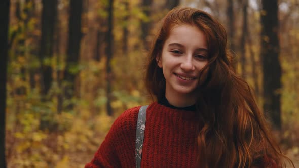 Young Girl Walking Through Autumn Park