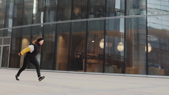 Slowmo of Male and Female Athletes Performing Parkour Stunts Outdoors