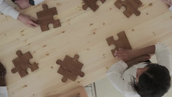 Business people assembling wooden puzzle