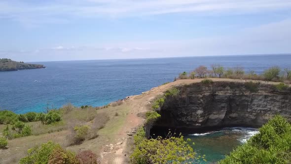 Buttery soft aerial view flight fly forwards drone shotBroken Beach at Nusa Penida in Bali Tropical