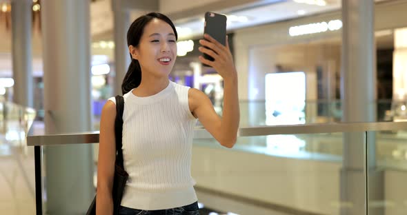 Woman using smart phone with shopping bags 