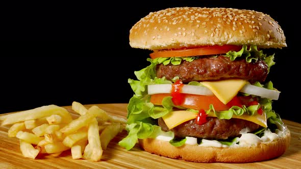 Craft Beef Burger and French Fries on Wooden Table Isolated on Black Background